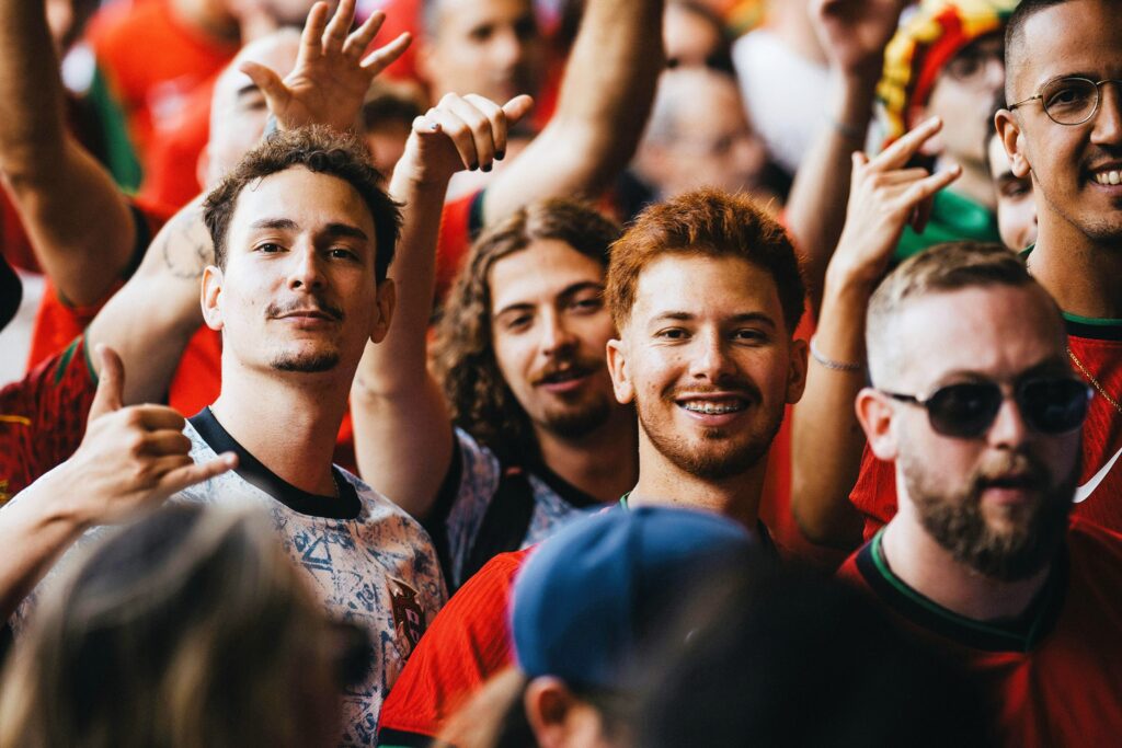 Brian Begin A group of people standing closely together at an event, some smiling and gesturing, all wearing casual clothing. Brian Begin Podcast