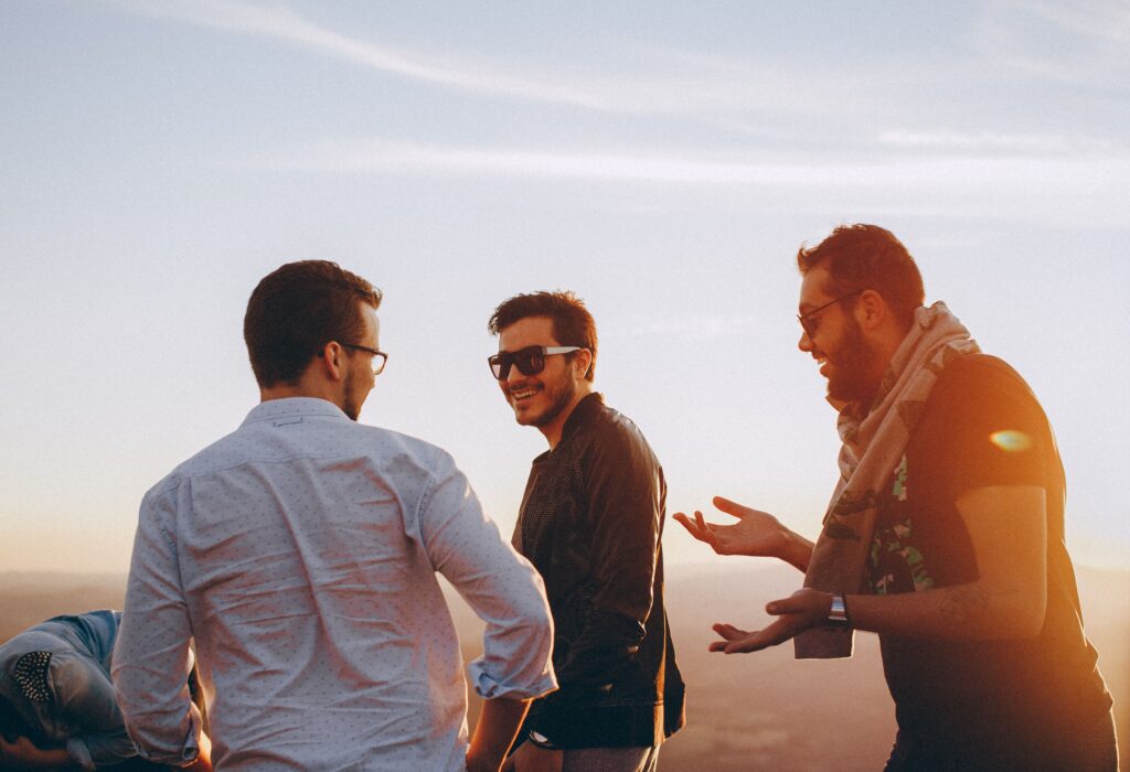 "Group of men connecting authentically, representing the brotherhood and transformation available through True Courage coaching"