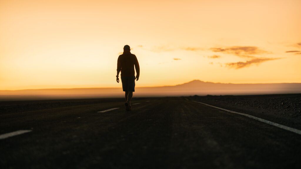 "Man walking confidently toward open horizon representing the transformation available through emotional embodiment work"